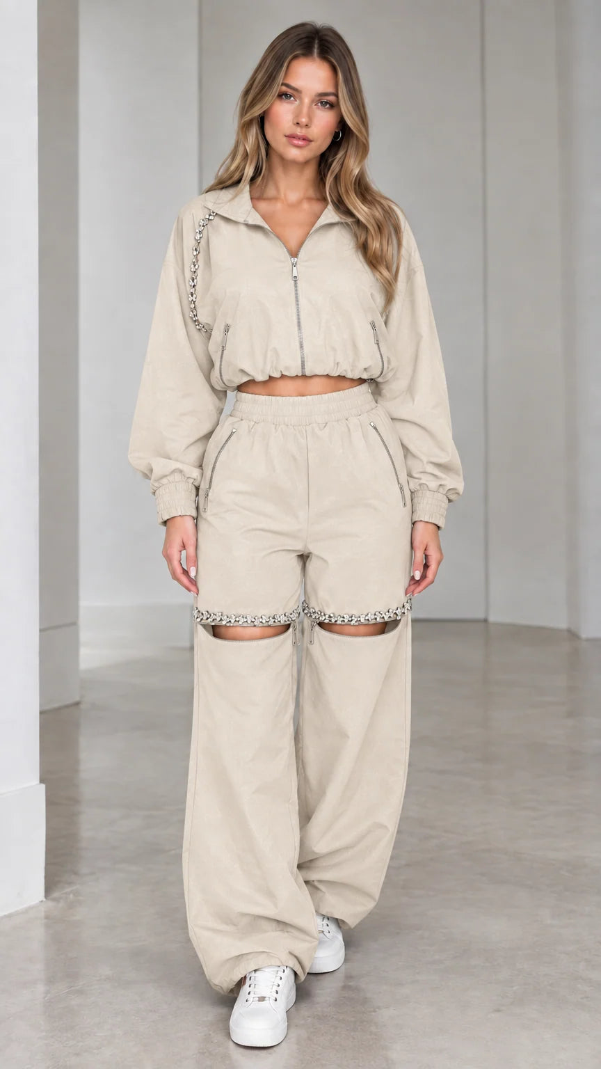 Model wearing beige cream cropped zip jacket and rhinestone cut-out wide leg pants set
