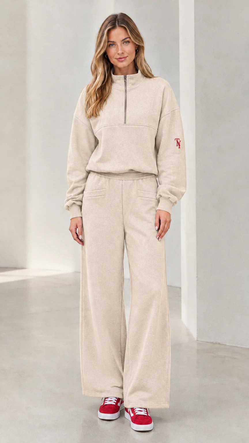Front view of woman wearing beige half-zip pullover and wide-leg lounge set