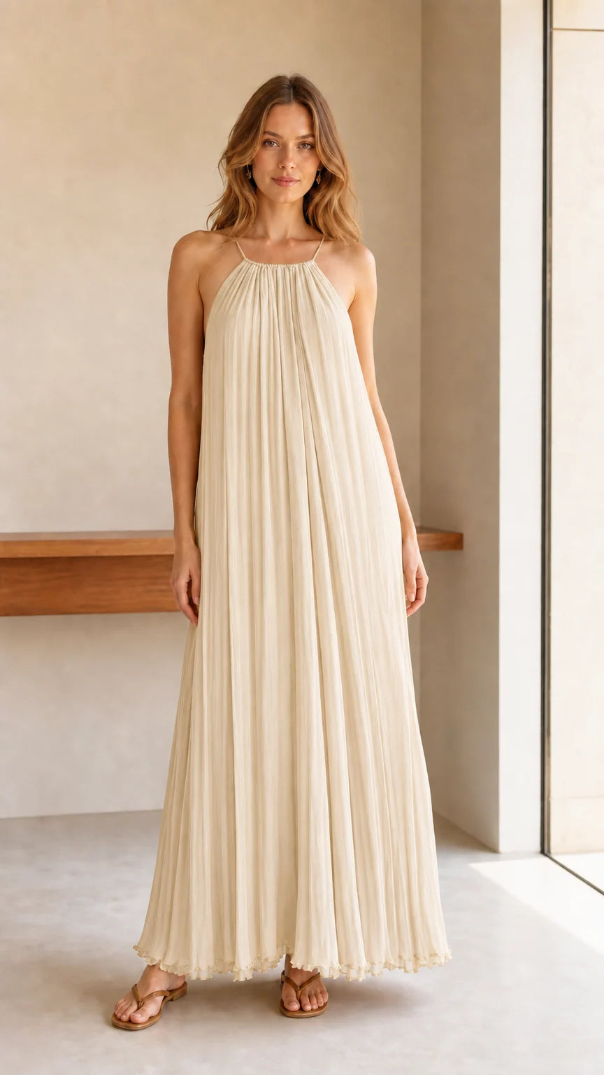 Model wearing cream pleated halter maxi dress